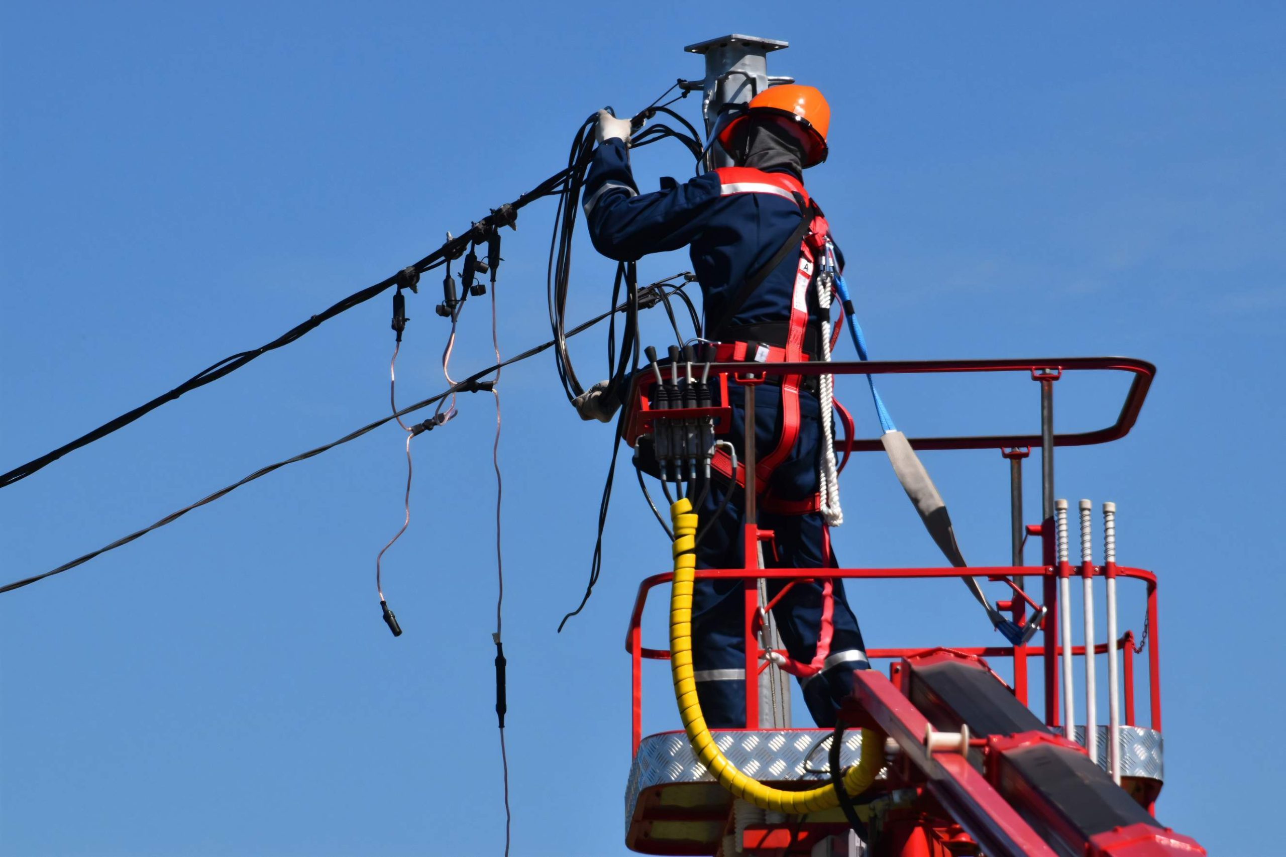 A power grid staff is inspecting power lines